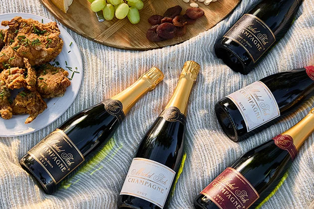 Champagne laid out on a blanket for a picnic