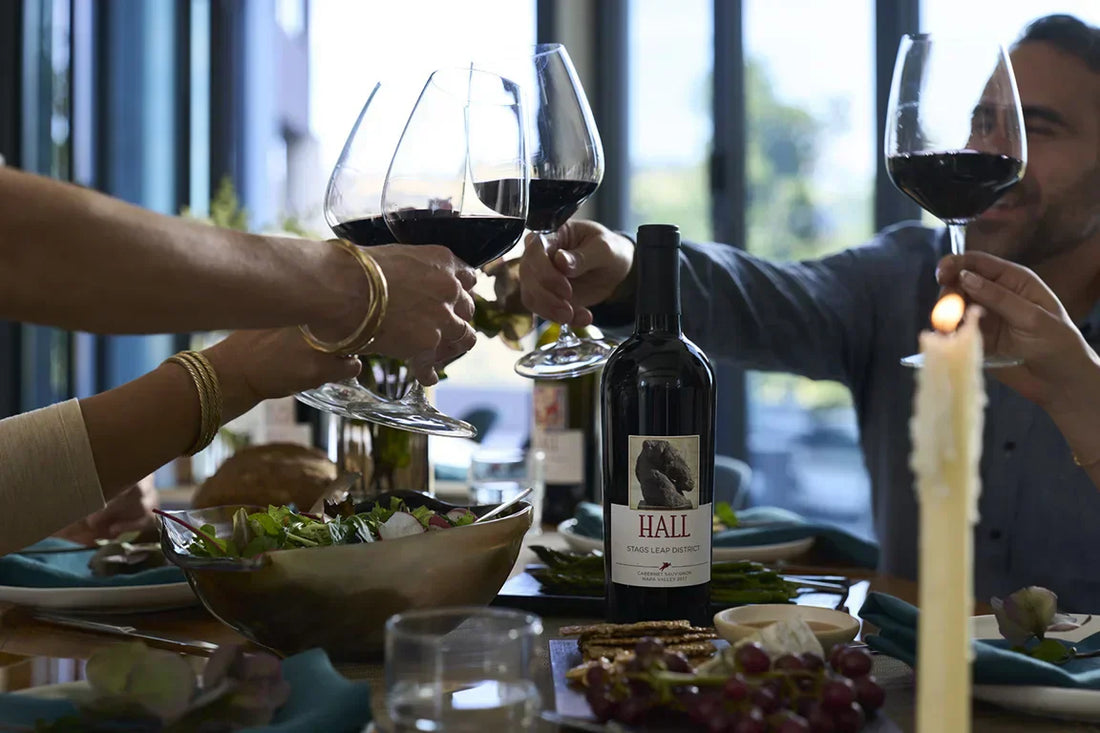 Full wine glasses coming together to cheers at the dinner table