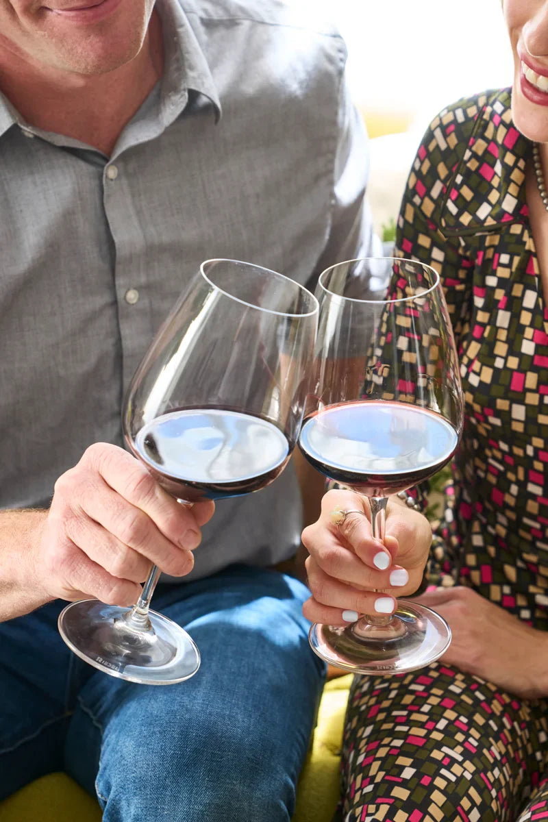 Smiling couple toasting with glasses of 2019 HALL Craig's Cabernet Sauvignon