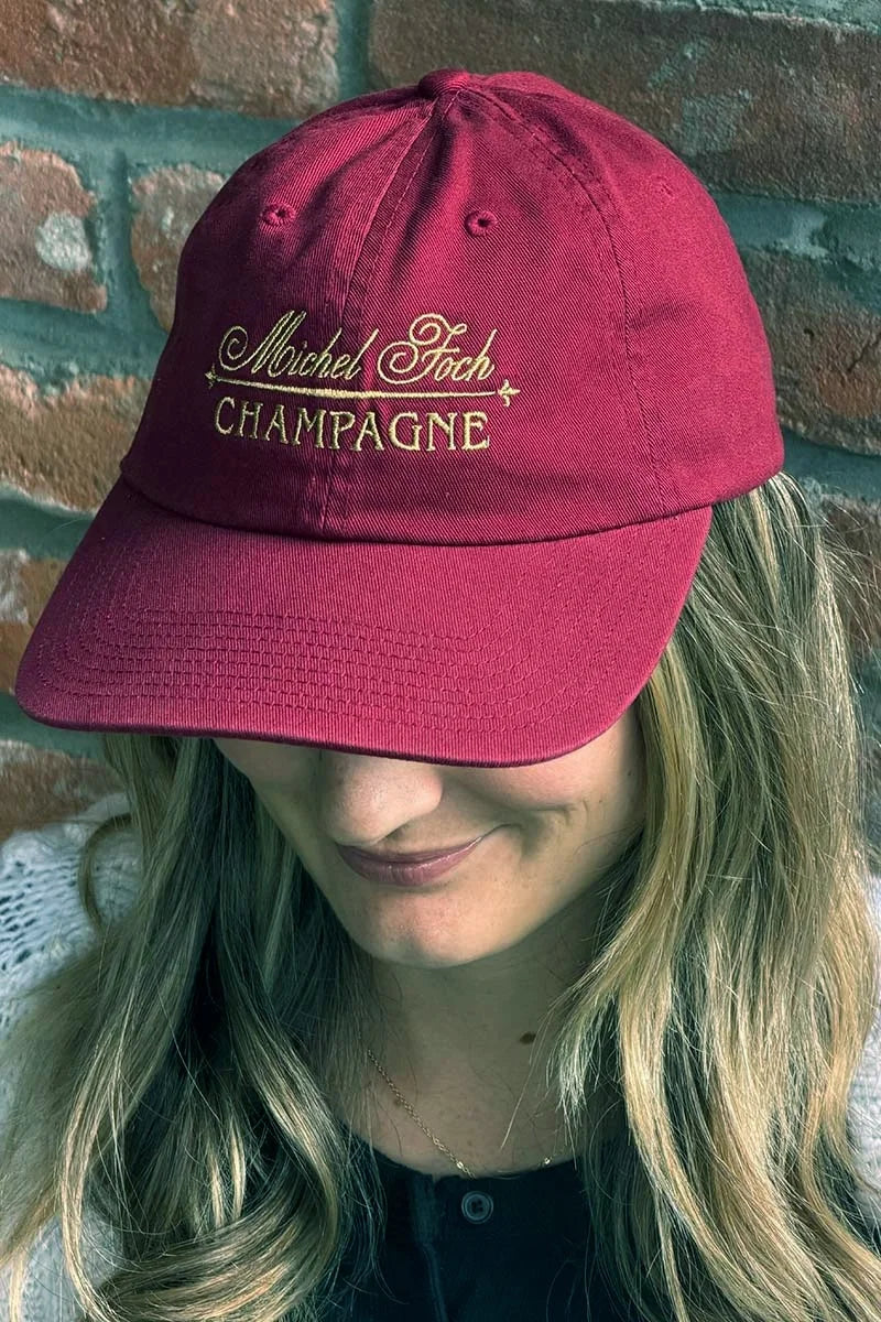 Image of a woman wearing a Michel Foch Champagne ball cap.