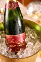 Bottle of Michel Foch Burt Champagne 2013 Vintage in a gold ice bucket.