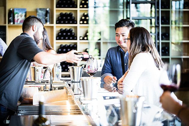A couple enjoying a private wine tasting experience at HALL St. Helena's modern tasting gallery. 