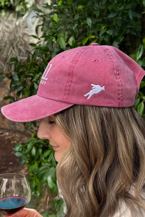 Image of a woman wearing a HALL nautical red baseball cap.
